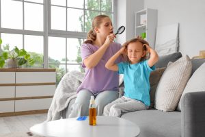 Parent at home inspecting a child's scalp with a magnifying glass, looking for nits and live lice during the kind of careful home head check that surfaces the find-nits-but-no-crawling-bugs decision the article walks through.