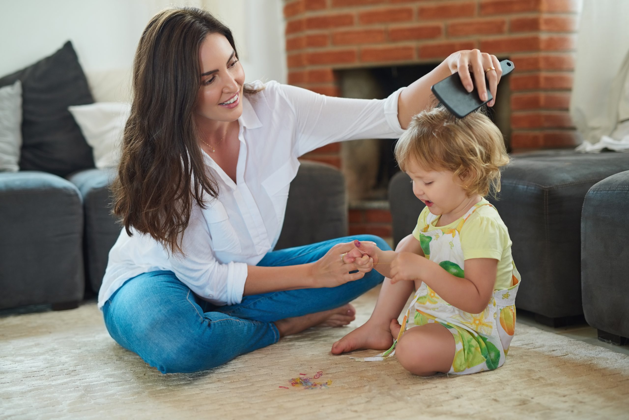 Woman Brushing Toddler's Hair in Living Room
