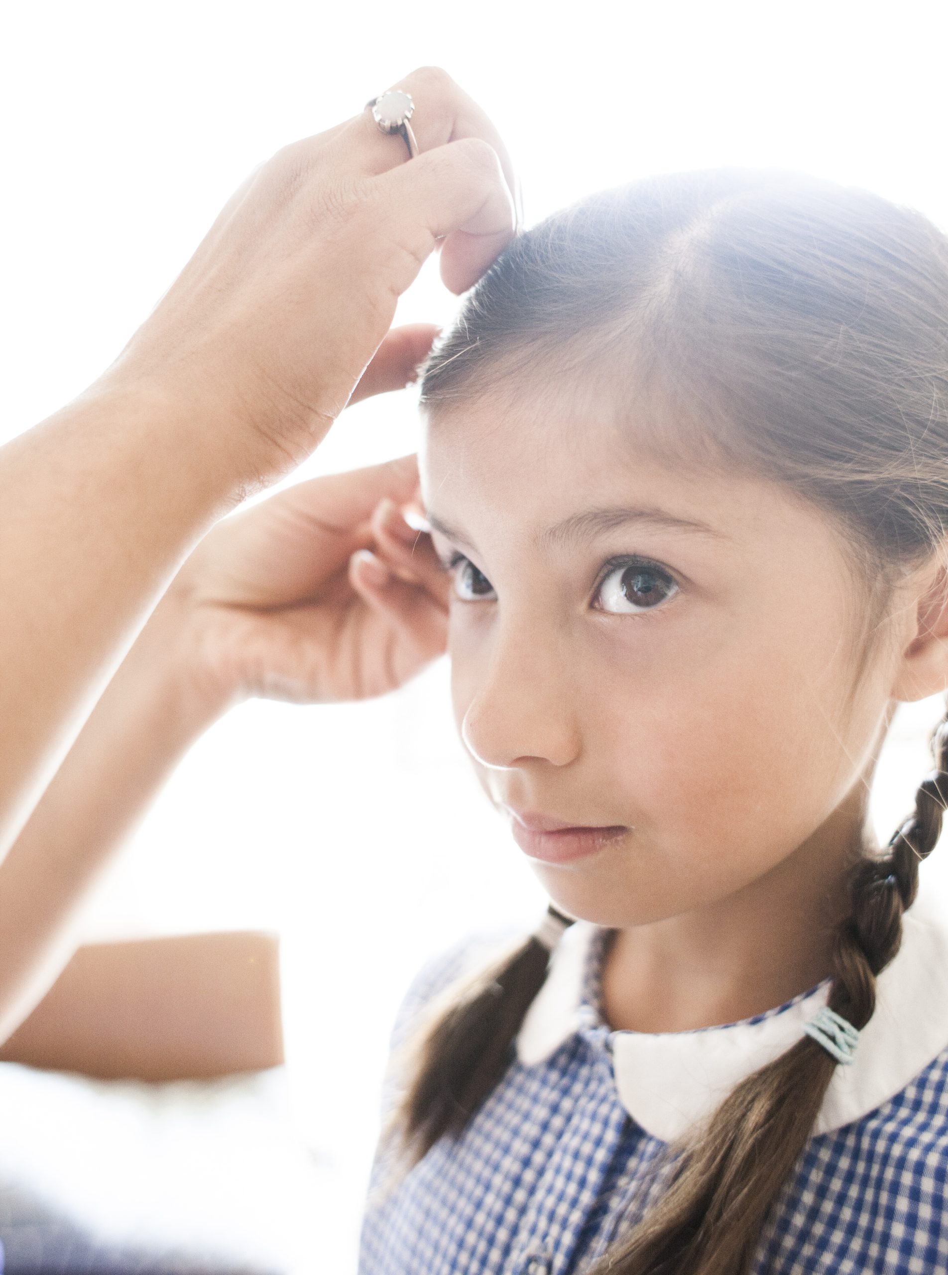 Girl Getting Hair Done by Adult in Home