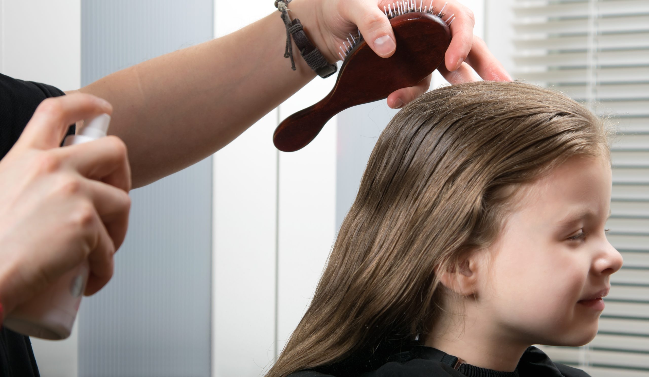 young girl doing a hairdress, wetting her hair, she smiles